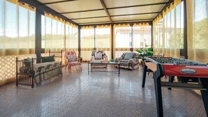 A covered outdoor area with a foosball table, two sofas, and a small table. - Casa Eda, in the green hills of Lucca and 5 minutes from the historic center (Lucca)