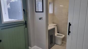 A bathroom with a toilet, a sink, and a framed certificate on the wall.
