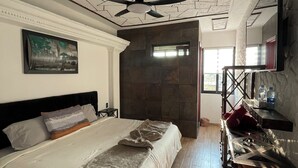 A bedroom with a bed, a ceiling fan, a painting, and a wooden floor. - Hotel y Restaurante ALDU (Malinalco)