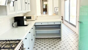 A kitchen with white cabinets, a gas stove, a microwave, and a refrigerator. - Large duplex with garden in Auray town center (Auray)