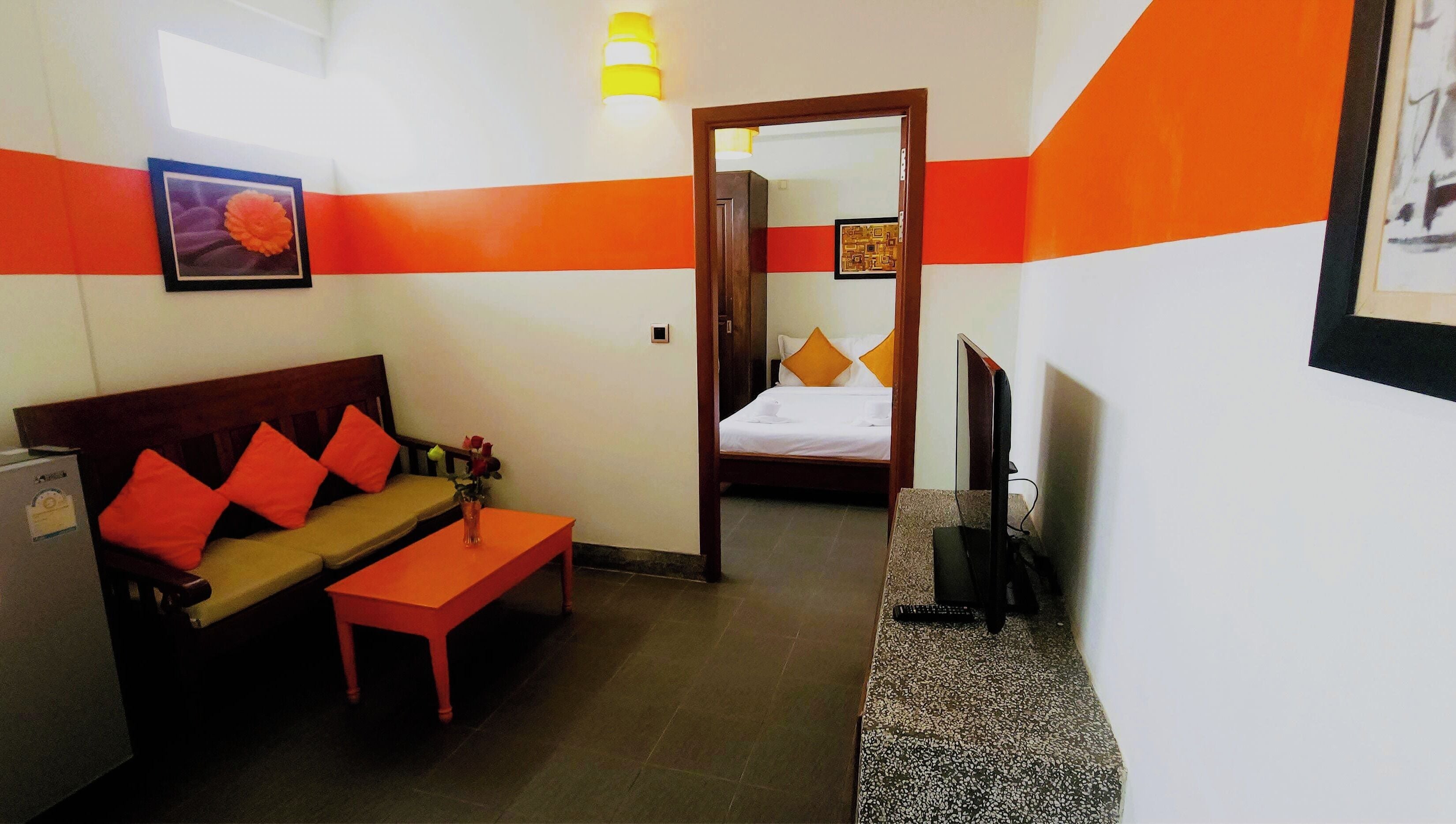 Habitació d'hotel amb un sofà, una taula petita, una televisió i un llit.