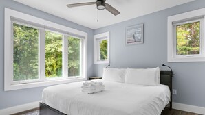 A bedroom with a large bed, multiple windows, a ceiling fan, and a rug. - Private & Quiet Retreat Near Folly Beach (Charleston)