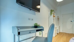 A modern bedroom with a desk, chair, and a TV mounted on the wall. - Italianflat - Elegant Suites (Milan)