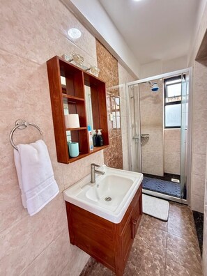 Een douche, handdoeken, zeep, toiletpapier