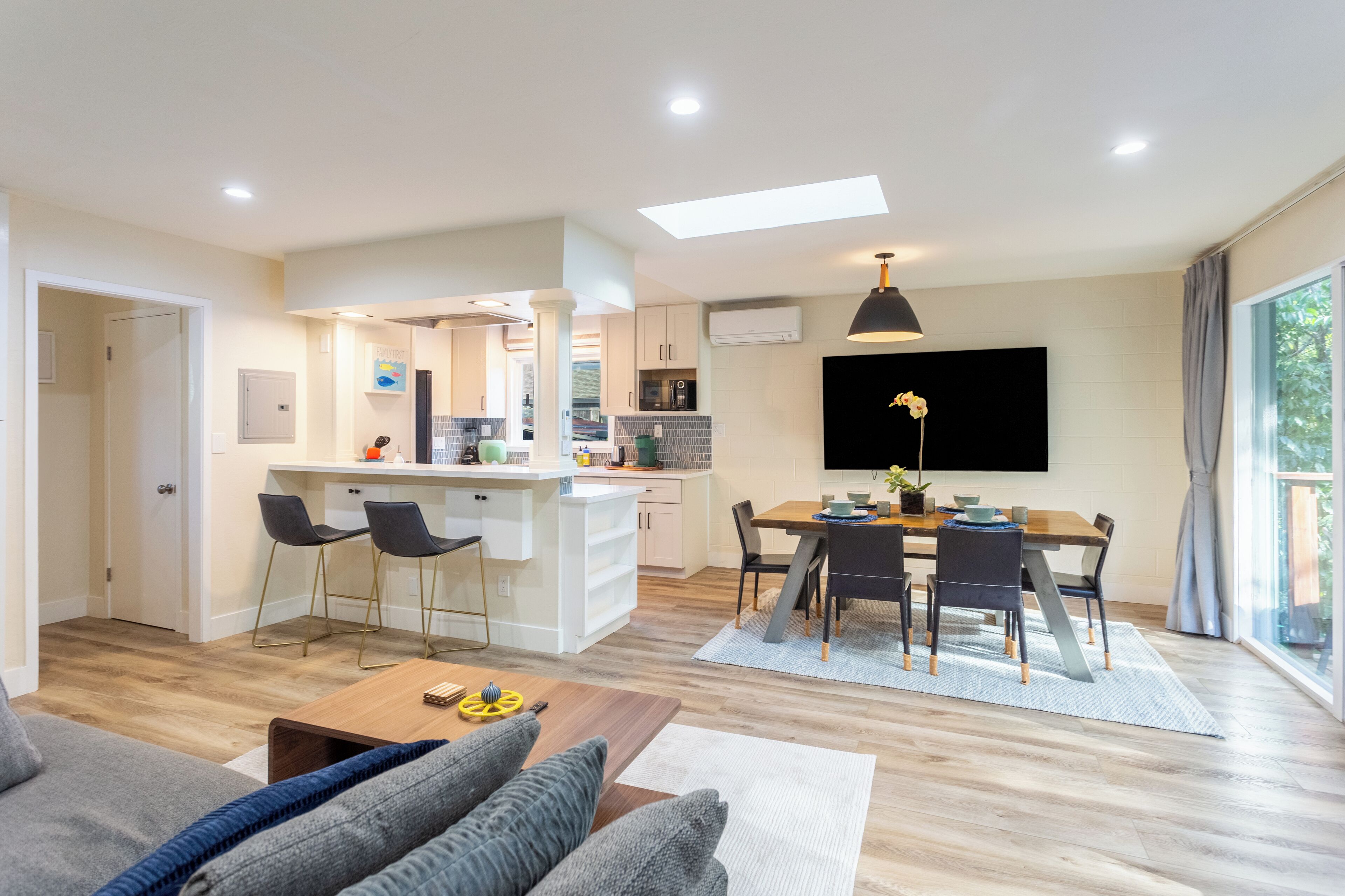 Een modern appartement met een woonkamer, eethoek, keuken en een balkon.