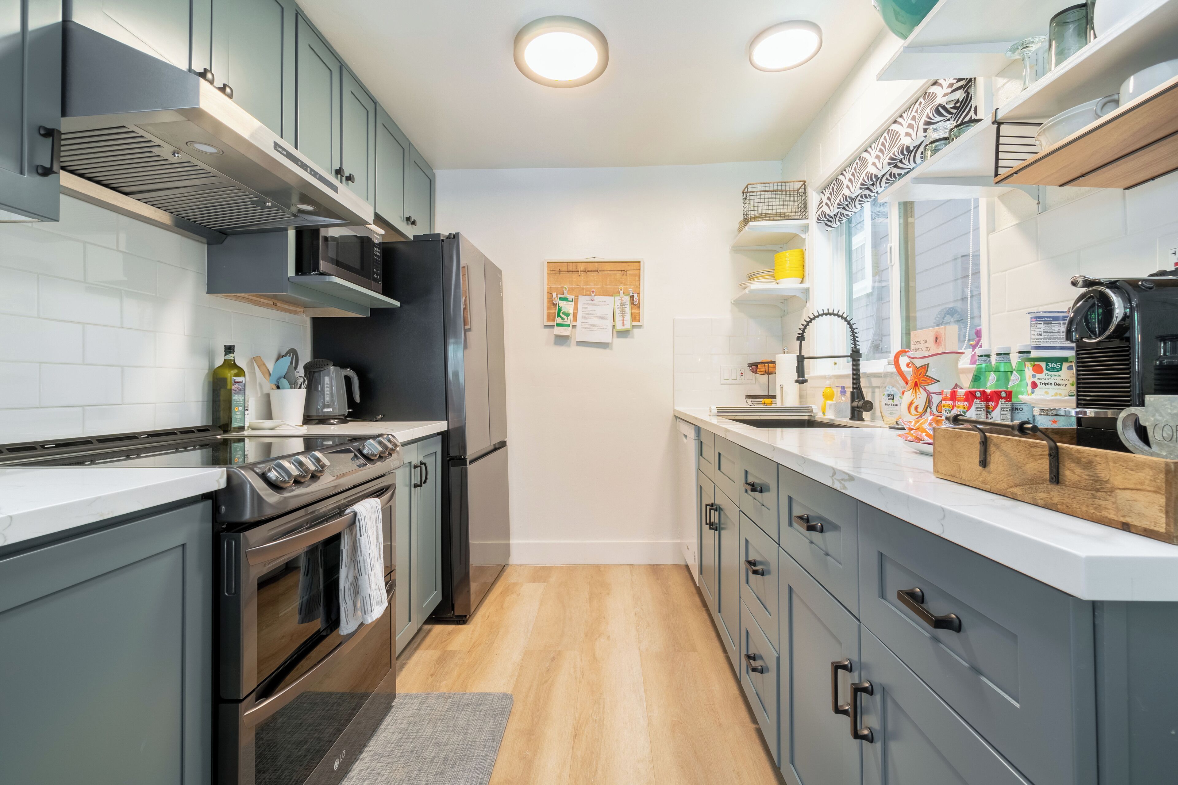 A modern kitchen with a built-in oven, microwave, and refrigerator. There is a wooden countertop and a sink with a faucet.