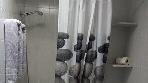 Un baño con bañera, inodoro y cortina de ducha.