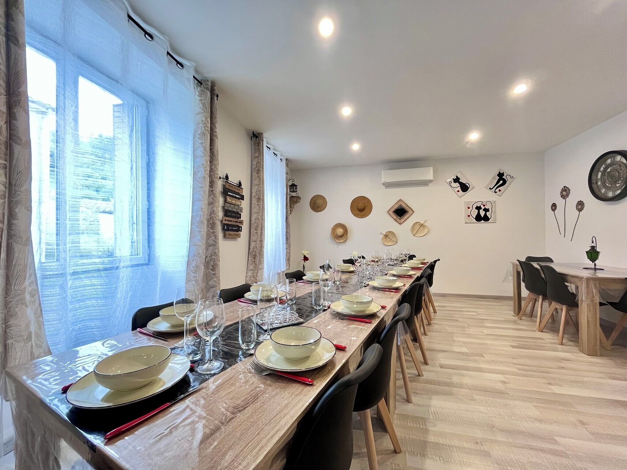 Un comedor con una mesa larga dispuesta para una comida, rodeada de sillas.