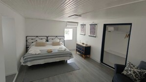 Quarto com cama, cômoda e guarda-roupa.
