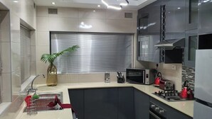 Una cocina moderna con una isla central, electrodomésticos de acero inoxidable y una planta en maceta.