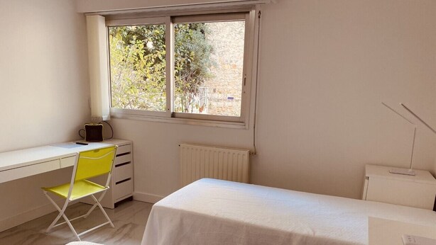 A bedroom with a single bed, a desk with a chair, a radiator, and a window with a view of greenery. - Renovated studios in the center of Cannes an easy walk to the beaches and the Palais des Festivals - 2079 (Cannes)