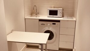 A compact laundry room with a washing machine, a microwave, and a sink. - Renovated studios in the center of Cannes an easy walk to the beaches and the Palais des Festivals - 2079 (Cannes)