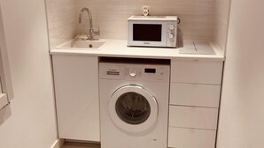 A compact laundry room with a washing machine, a microwave, and a sink. - Renovated studios in the center of Cannes an easy walk to the beaches and the Palais des Festivals - 2079 (Cannes)