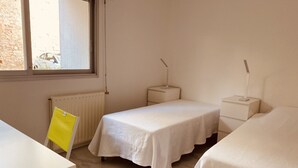 A bedroom with two single beds, a small table, a chair, and a window with a view of the outside. - Renovated studios in the center of Cannes an easy walk to the beaches and the Palais des Festivals - 2079 (Cannes)