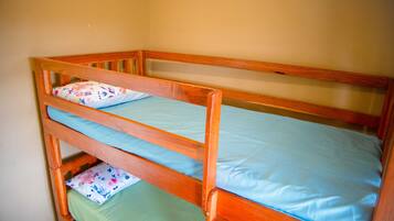 A bunk bed with two levels, each with a pillow and a mattress.