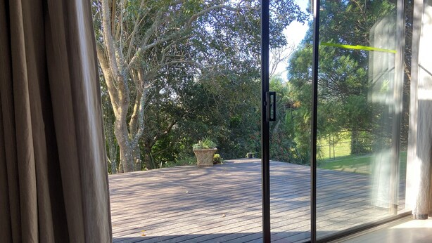 A wooden deck with a welcome mat and a doormat.