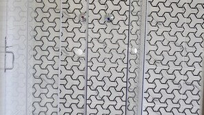 Een douchecabine met een wand met een geometrisch patroon.