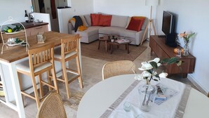 Un salon moderne comprenant un canapé, une table basse, une table à manger et des chaises.