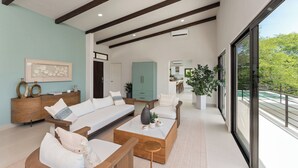A spacious living area with a sofa set, coffee table, and a view of the outdoors. - Stunning ocean view house in CocoBay Estates (Coco)