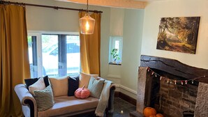 Una sala de estar acogedora con sofá, chimenea y un ventanal grande.