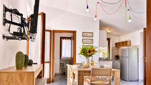 Una cucina moderna con zona pranzo, TV integrata e lampadario a soffitto.