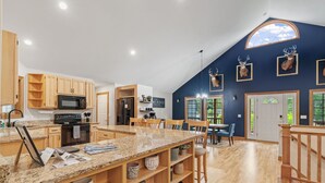 A spacious kitchen with granite countertops, wooden cabinets, and a large island. - Eagle Ridge (Menomonie)