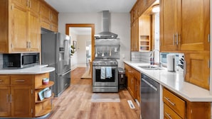 Una cocina moderna con armarios de madera, electrodomésticos de acero inoxidable y una isla central.