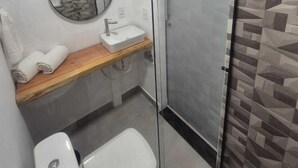 A modern bathroom with a toilet, sink, and shower. - Hotel Fortunato (Braganca Paulista)