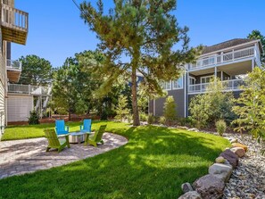 A residential property with a well-maintained lawn, outdoor seating area, and a two-story building with balconies.