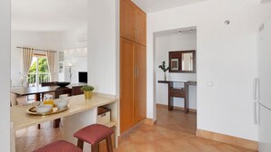 Una cocina moderna con comedor, armarios de madera y vistas al exterior.