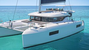 Een witte catamaran met een afgedekt dek, een loungeruimte en zitplaatsen.