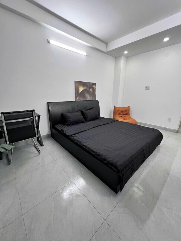 Un dormitorio moderno con una cama grande, un escritorio y una silla.