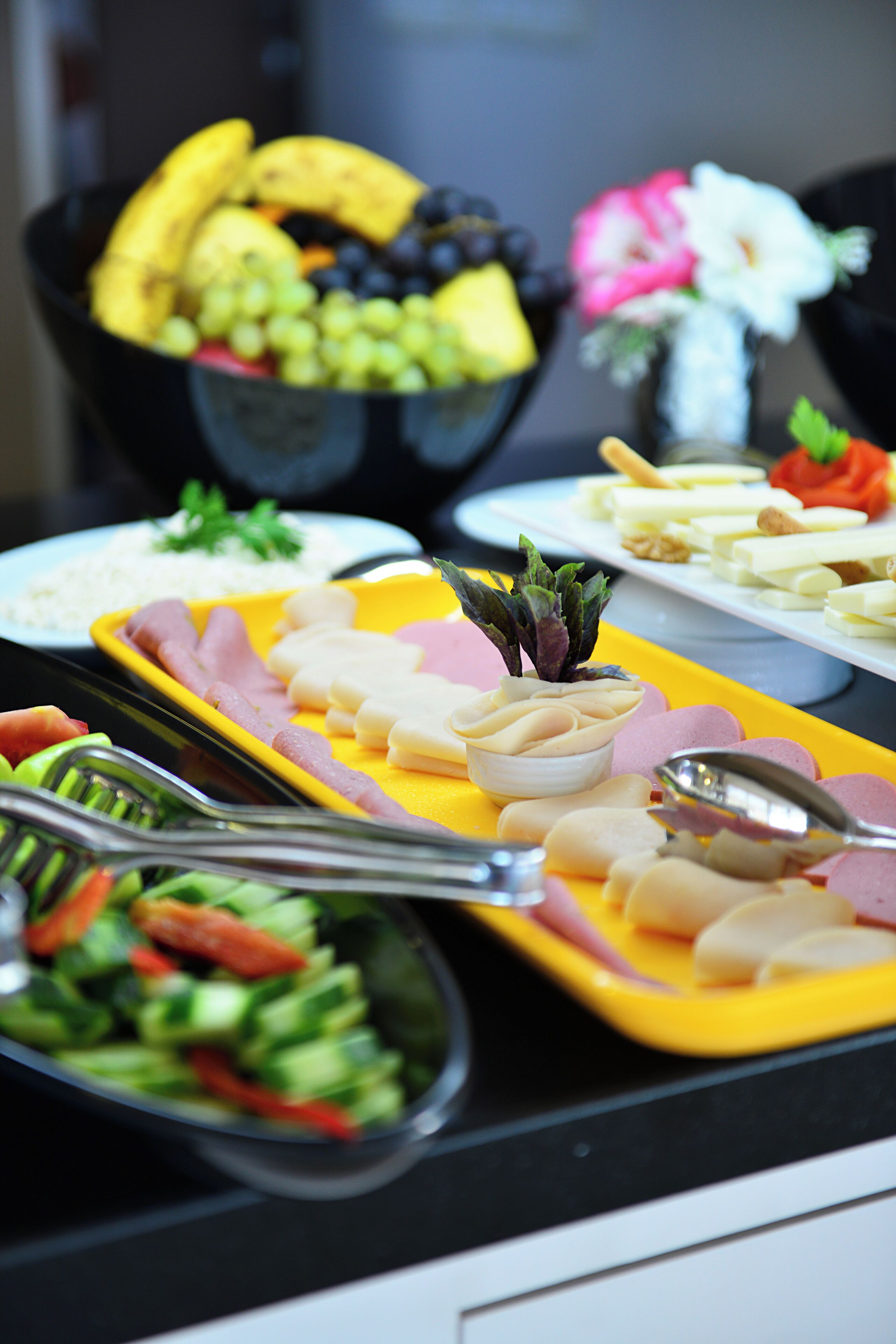 Ein Buffet mit verschiedenen Speisen, darunter Obst, Gemüse und Fleisch.