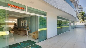 A hotel lobby with a Christmas tree, a reception desk, and a beach class sign. - Apt With River View and Balcony Pontal Bcl402 (Ilhéus)