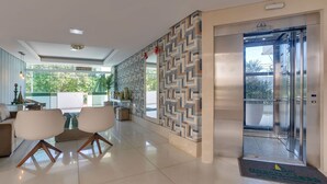 Un intérieur moderne comprenant un coin repas, un mur décoré de motifs et un ascenseur.