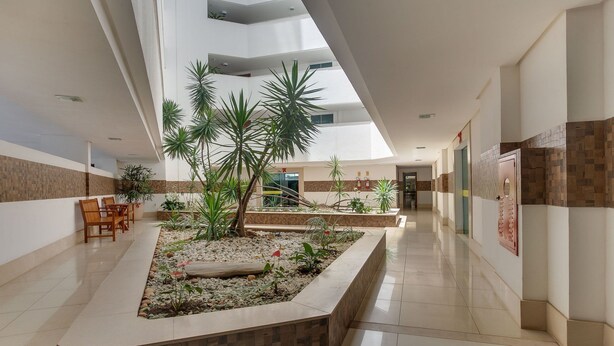 Un vaste espace intérieur doté d’un jardin central, de coins salon et d’un haut plafond agrémenté de lucarnes.