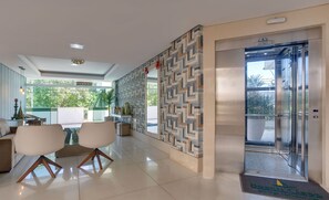 Un intérieur moderne comprenant un coin repas, un mur décoré de motifs et un ascenseur.