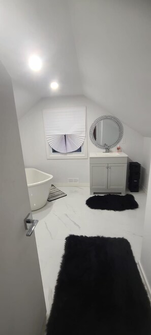 Luxe kamer | Badkamer | Een bad/douchecombinatie, handdoeken, toiletpapier