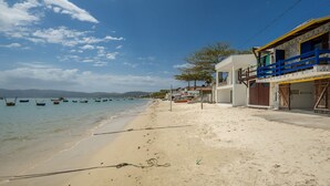 Una spiaggia con barche, una riva sabbiosa e edifici con facciata blu e bianca.