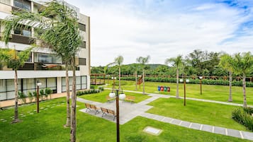 Un edificio moderno con un patio que incluye bancos, un sendero y un césped bien cuidado.