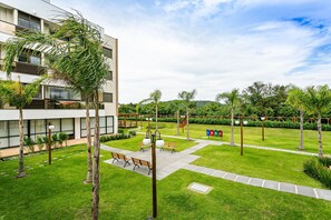 Un edificio moderno con un patio que incluye bancos, un sendero y un césped bien cuidado.