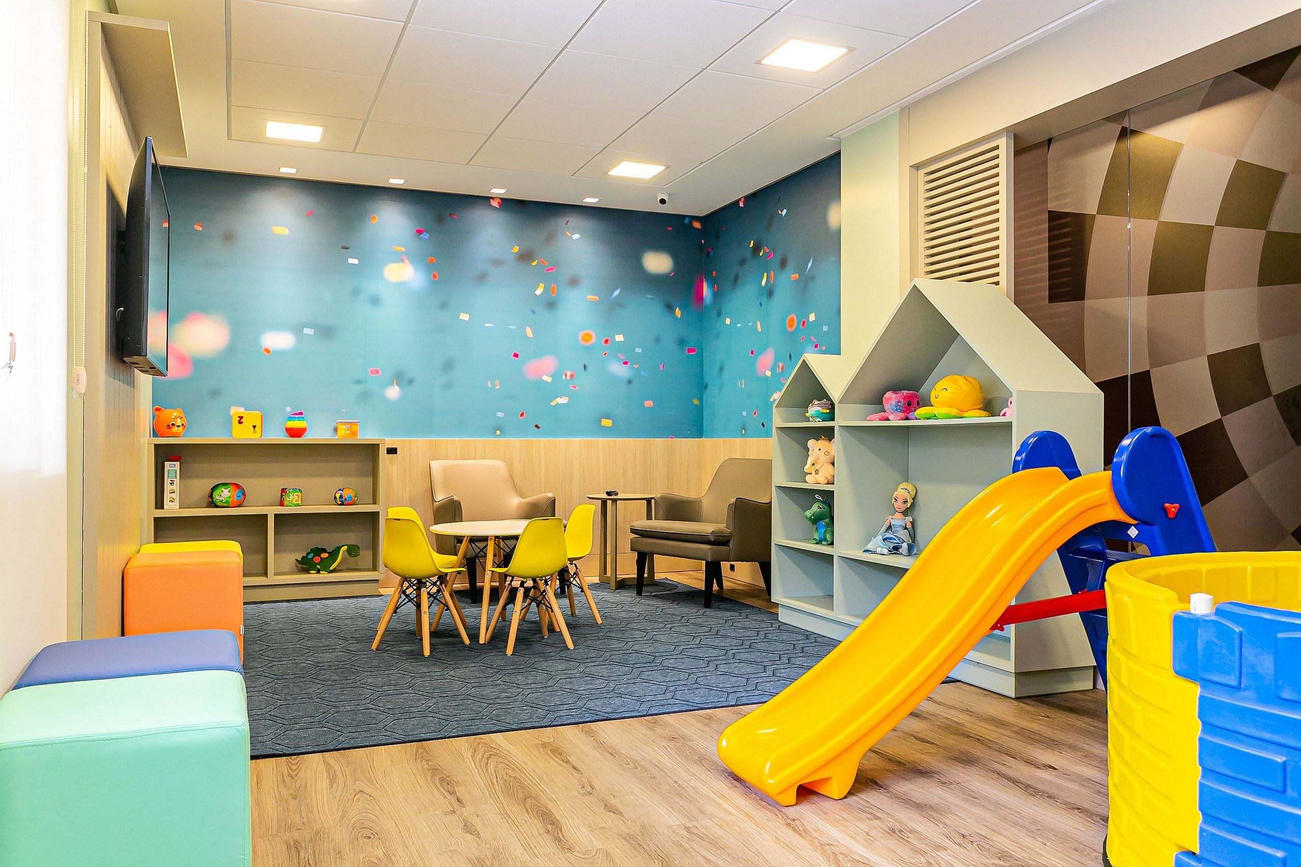 A children's play area with a slide, seating, and toys.