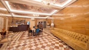 A lobby with a checkered floor, a bar area, a seating area, and a chandelier. - 2115 Boutique Hostel (Durrës)
