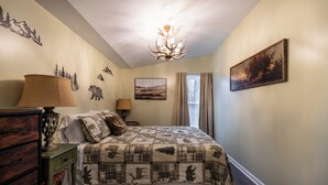 A bedroom with a bed, a dresser, a lamp, a painting, and a chandelier. - Cozy Fall Getaway- 35 Min to Bills Stadium- Wineries + Trails (Silver Creek)