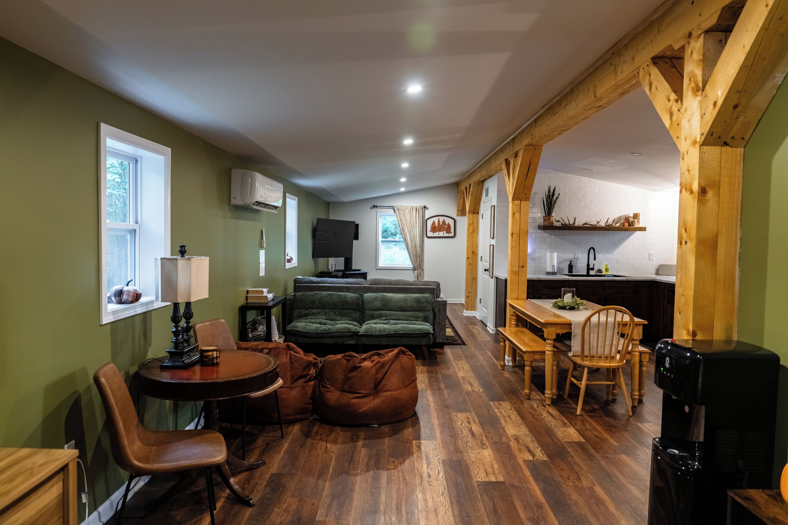 A cozy living area with a sofa, a dining table, and a kitchen area with a sink and countertop.