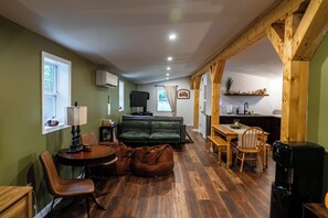 A cozy living area with a sofa, a dining table, and a kitchen area with a sink and countertop.