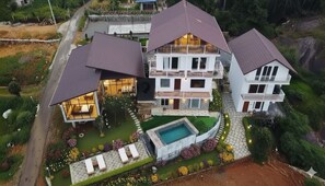 A modern two-story house with a swimming pool, surrounded by well-maintained gardens and a stone pathway. - Vagamon hill Casa holiday home (Peermade)