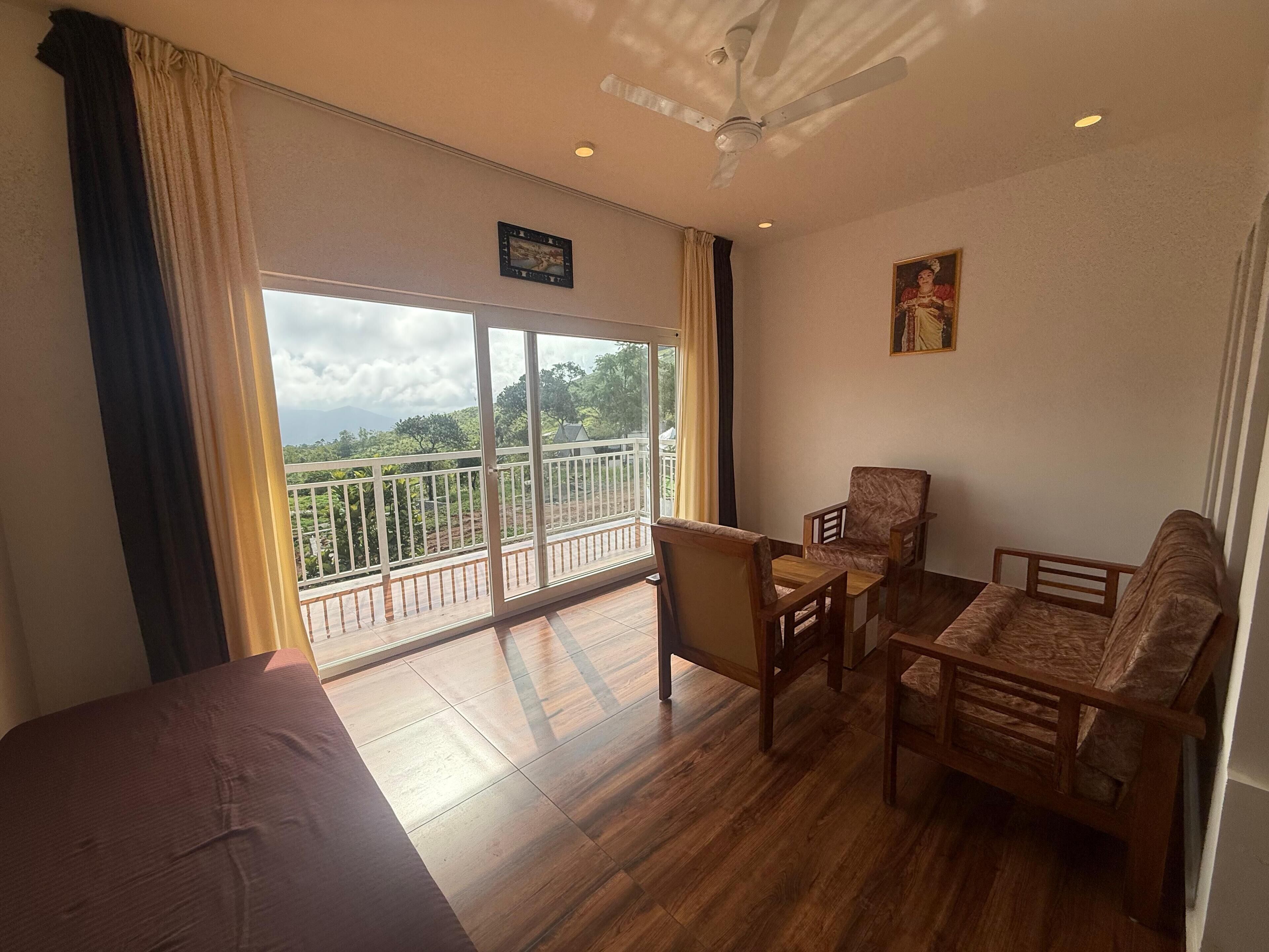 A room with a balcony, wooden furniture, and a ceiling fan.