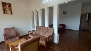 Un soggiorno con due divani, un tavolino da caffè, pavimento in legno e un quadro appeso al muro.