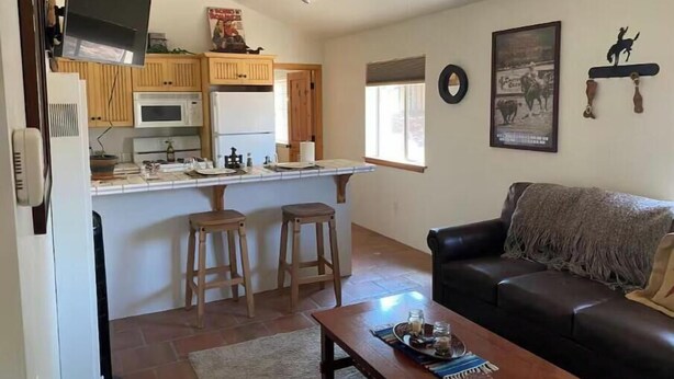 Un espacio habitable compacto con cocina, comedor y zona de estar.